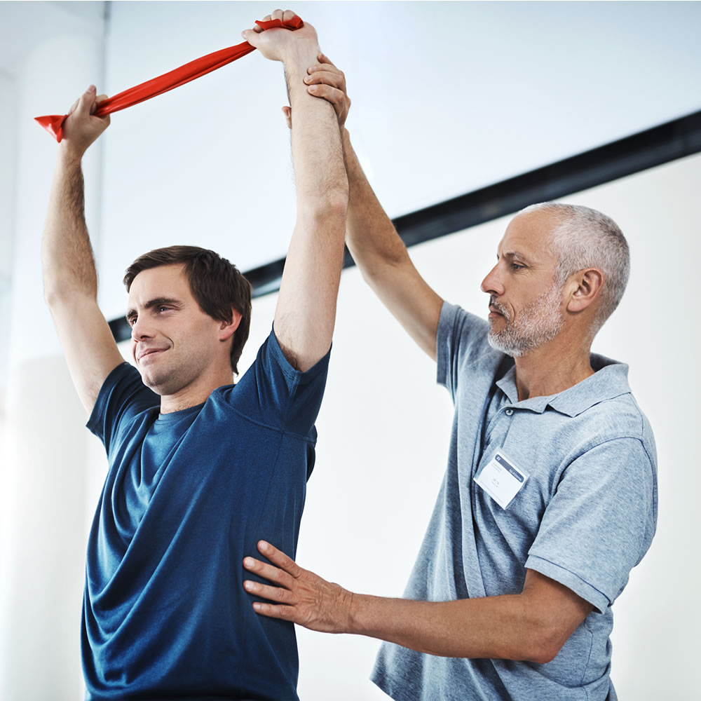Therapist guiding a patient through post-surgical rehabilitation exercises